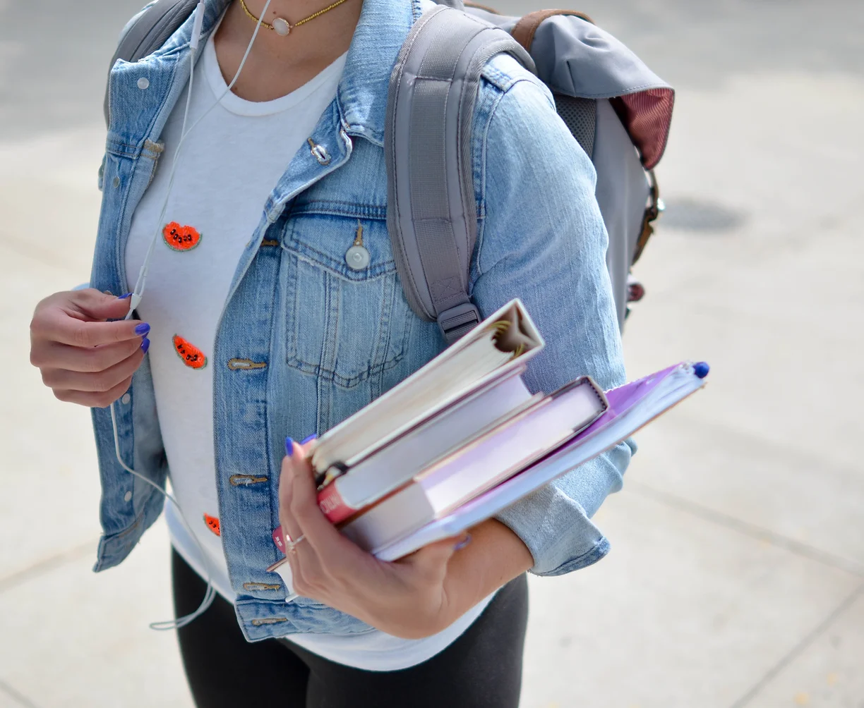 Student holding books outside